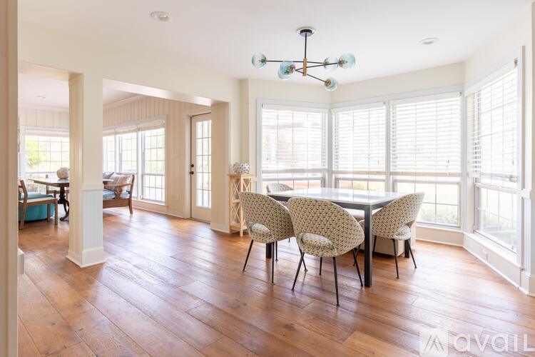 A dining room with a table and chairs.