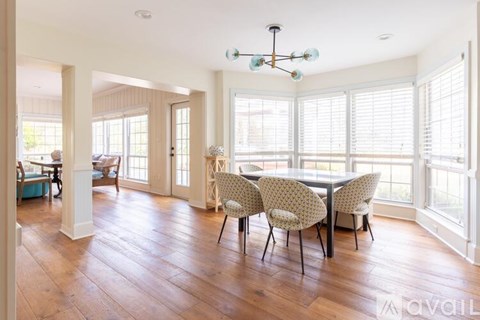 A dining room with a table and chairs.