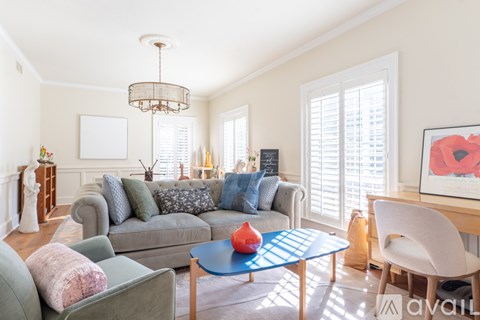 A living room with a grey couch and a blue coffee table.