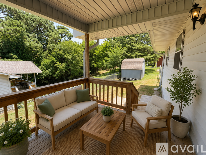 A wooden deck with a couch, chair, and table.