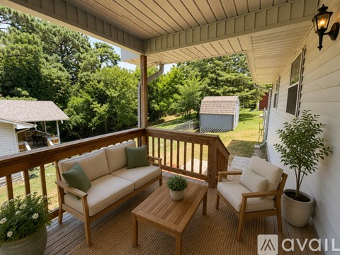 A wooden deck with a couch, chair, and table.