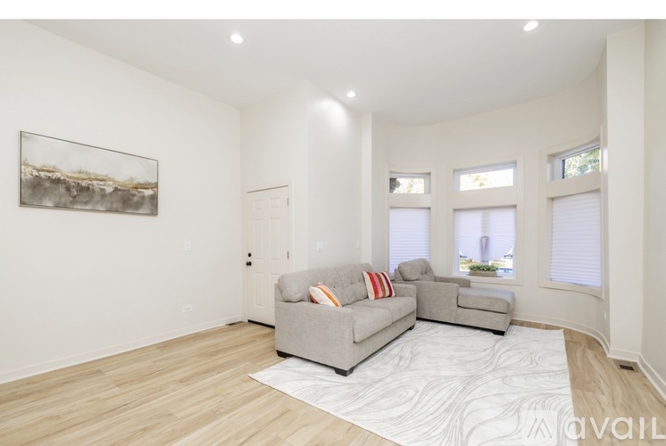 A living room with a grey couch and a rug.