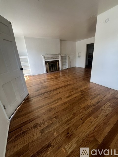 A room with wooden floors and a fireplace.