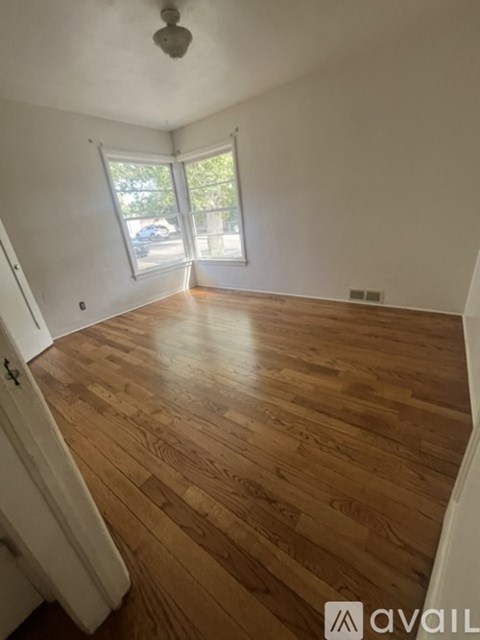 A room with wooden flooring and a window.