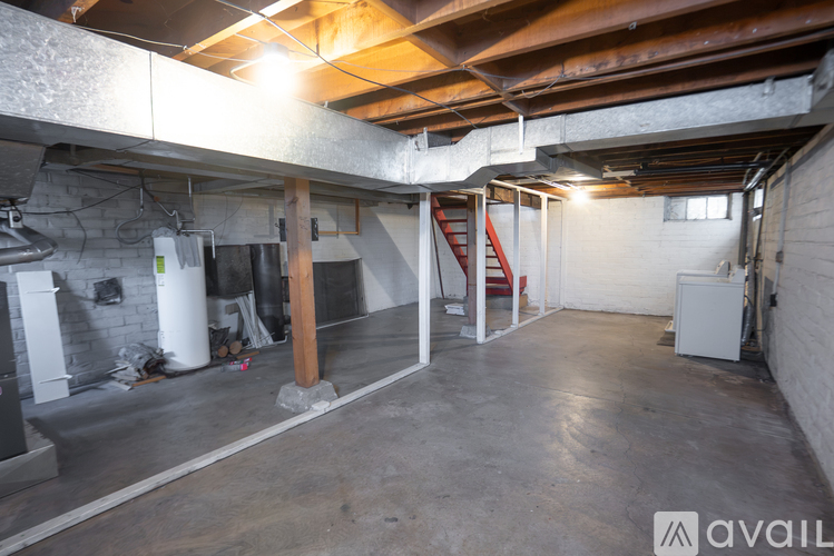 A large, empty basement with a fireplace and a staircase.