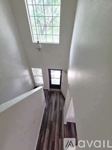 A hallway with a skylight and a small window.