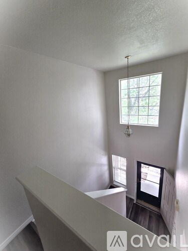 A room with a window and a chandelier.