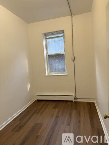 A room with wooden floors and a window.