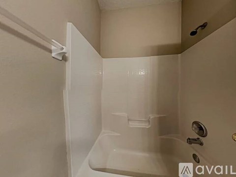 A white shower stall with a door open and a shower head.