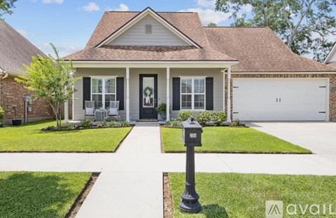 A house with a black front door and a mailbox on the lawn.