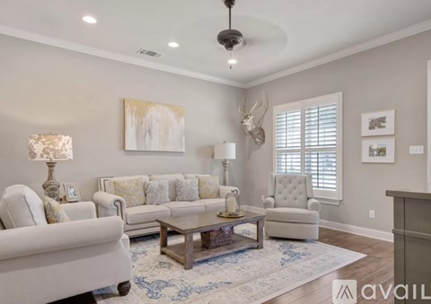 A living room with a white sofa, a wooden coffee table, and a painting on the wall.
