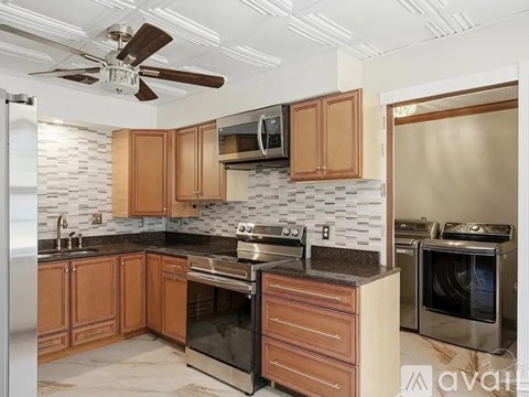 A kitchen with wooden cabinets and a black countertop.