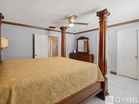 A bedroom with a four poster bed and a dresser.