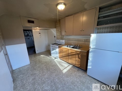 A kitchen with white appliances and wooden cabinets.