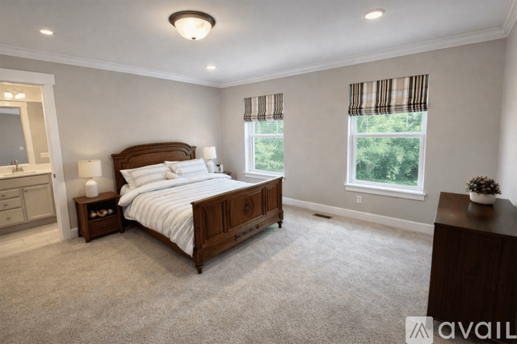 A bedroom with a large bed, a nightstand, and a dresser.