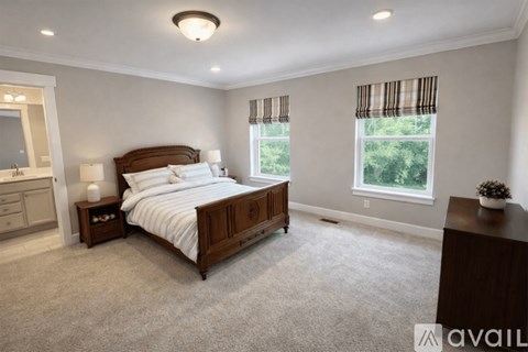 A bedroom with a large bed, a nightstand, and a dresser.
