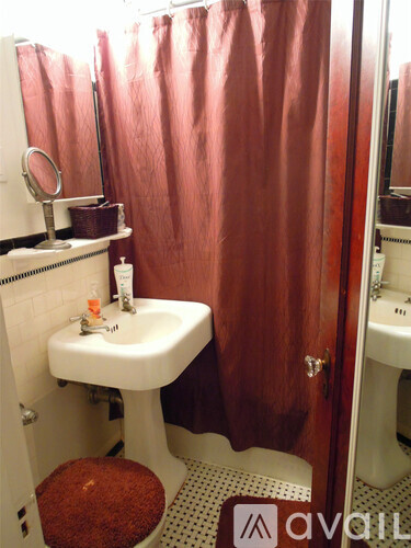 A bathroom with a white sink and brown shower curtain.