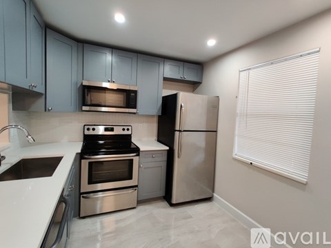 A kitchen with a stove, oven, refrigerator, and sink.