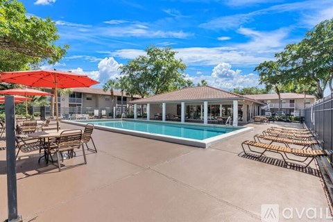 A pool area with sun loungers and umbrellas is available for use.