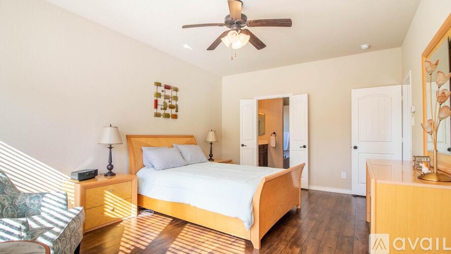 A bedroom with a bed, dresser, and mirror.