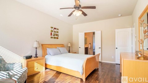 A bedroom with a bed, dresser, and mirror.