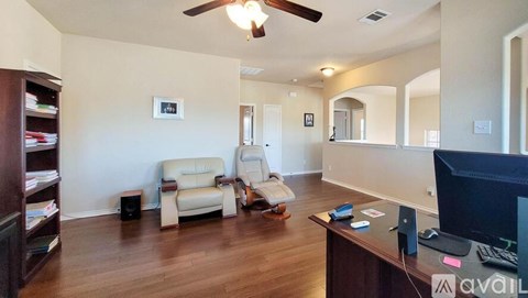 A living room with a white couch and a brown desk.
