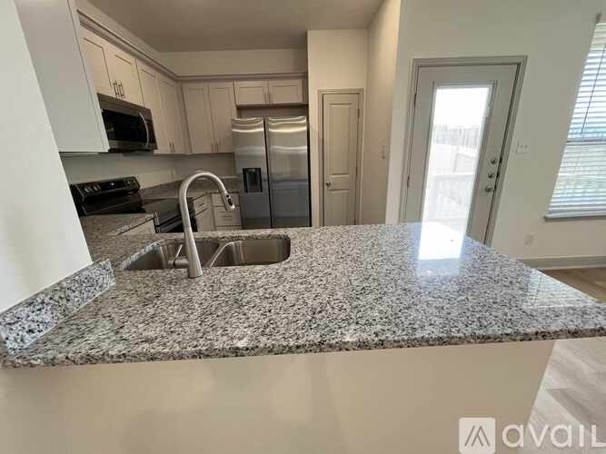 A kitchen with granite countertops and stainless steel appliances.
