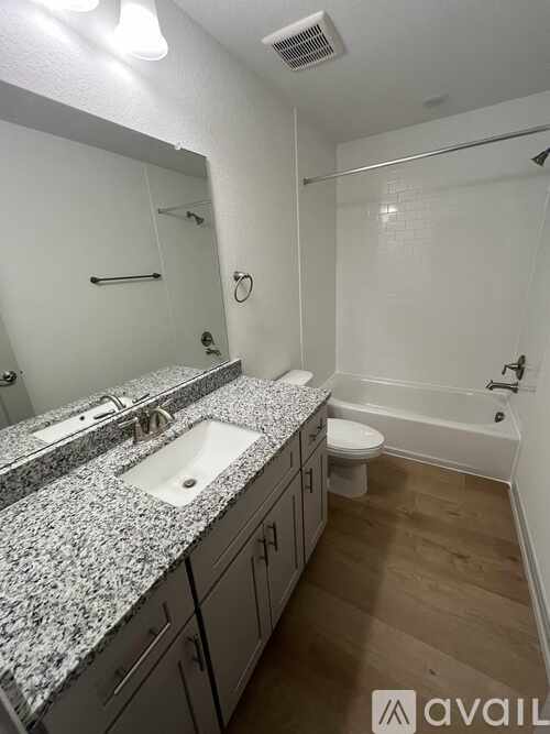 A bathroom with granite countertops and a walk-in shower.