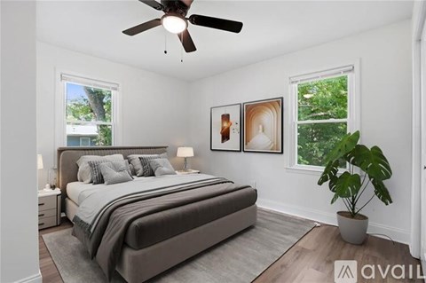 A bedroom with a large bed and a ceiling fan.