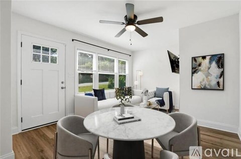 A dining room with a table, chairs, and a ceiling fan.