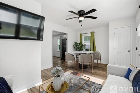 A living room with a white couch, a coffee table, and a ceiling fan.