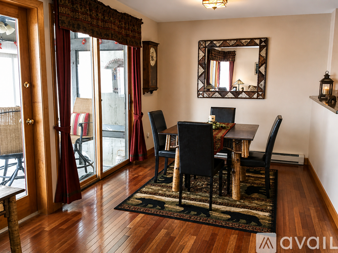 A dining room with a wooden table and chairs.