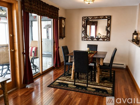 A dining room with a wooden table and chairs.