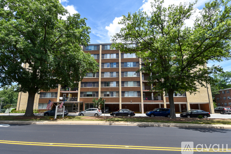 A large apartment building with a parking lot in front.