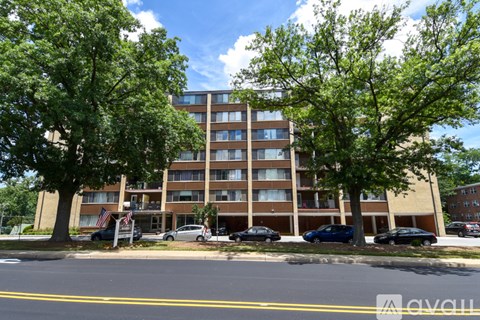 A large apartment building with a parking lot in front.