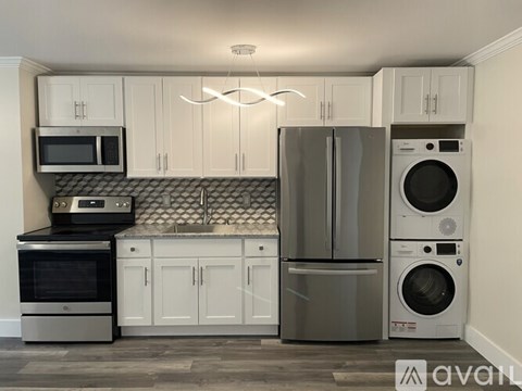 A kitchen with white cabinets and stainless steel appliances.