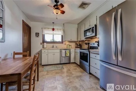 A kitchen with a refrigerator, oven, and sink.