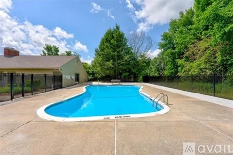 A swimming pool surrounded by a fence and trees.