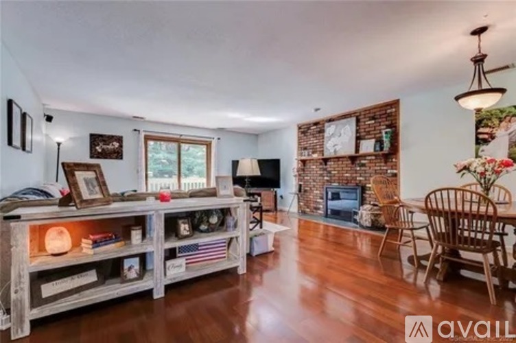 A living room with a wooden floor and a brick wall.