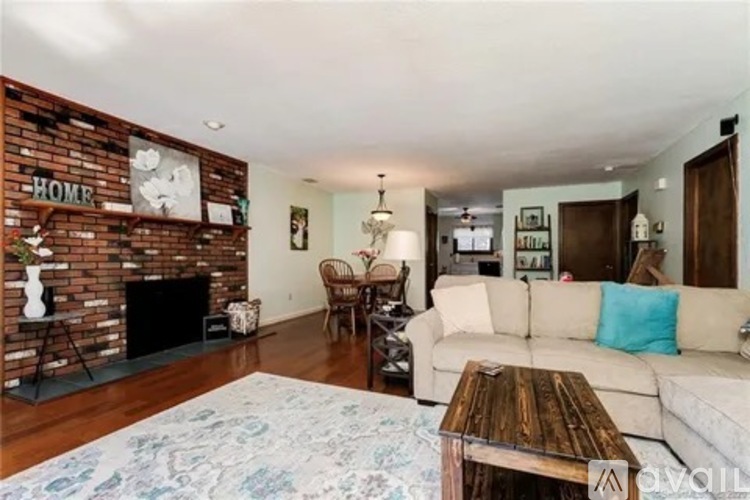 A living room with a brick fireplace and a white couch.