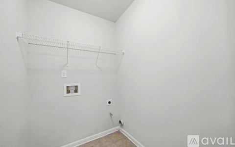 A white wall with a shelf and a picture frame.