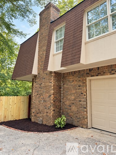 A house with a brick wall and a black door.