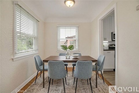 A dining room with a table and chairs.