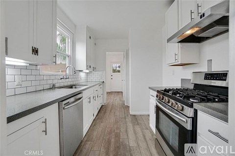 A kitchen with white cabinets and a black stove top oven.