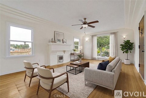 A living room with a fireplace, two chairs, and a couch.