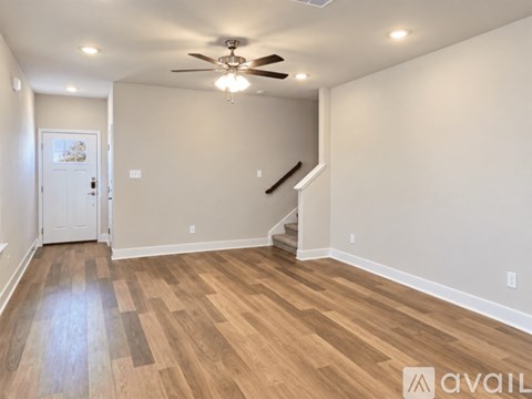 A room with a staircase and a ceiling fan.