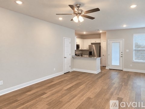 A spacious room with a ceiling fan and wooden flooring.