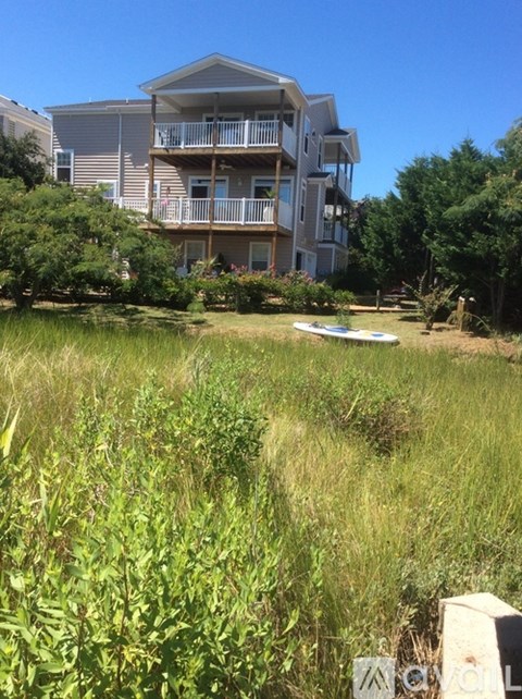 A grassy area in front of a two-story apartment building.