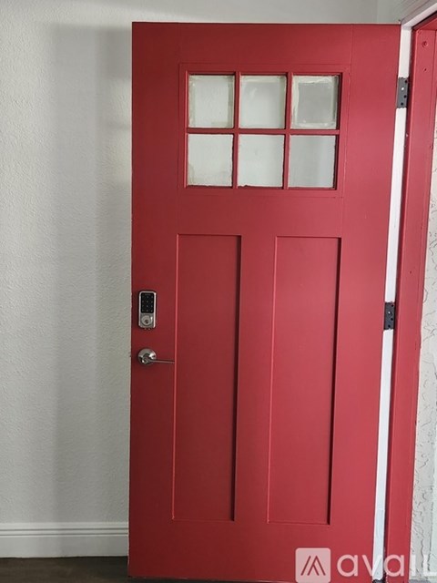 A red door with a glass panel and a handle.