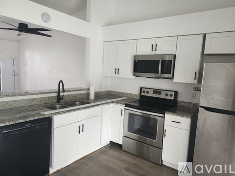 A kitchen with white cabinets and stainless steel appliances.